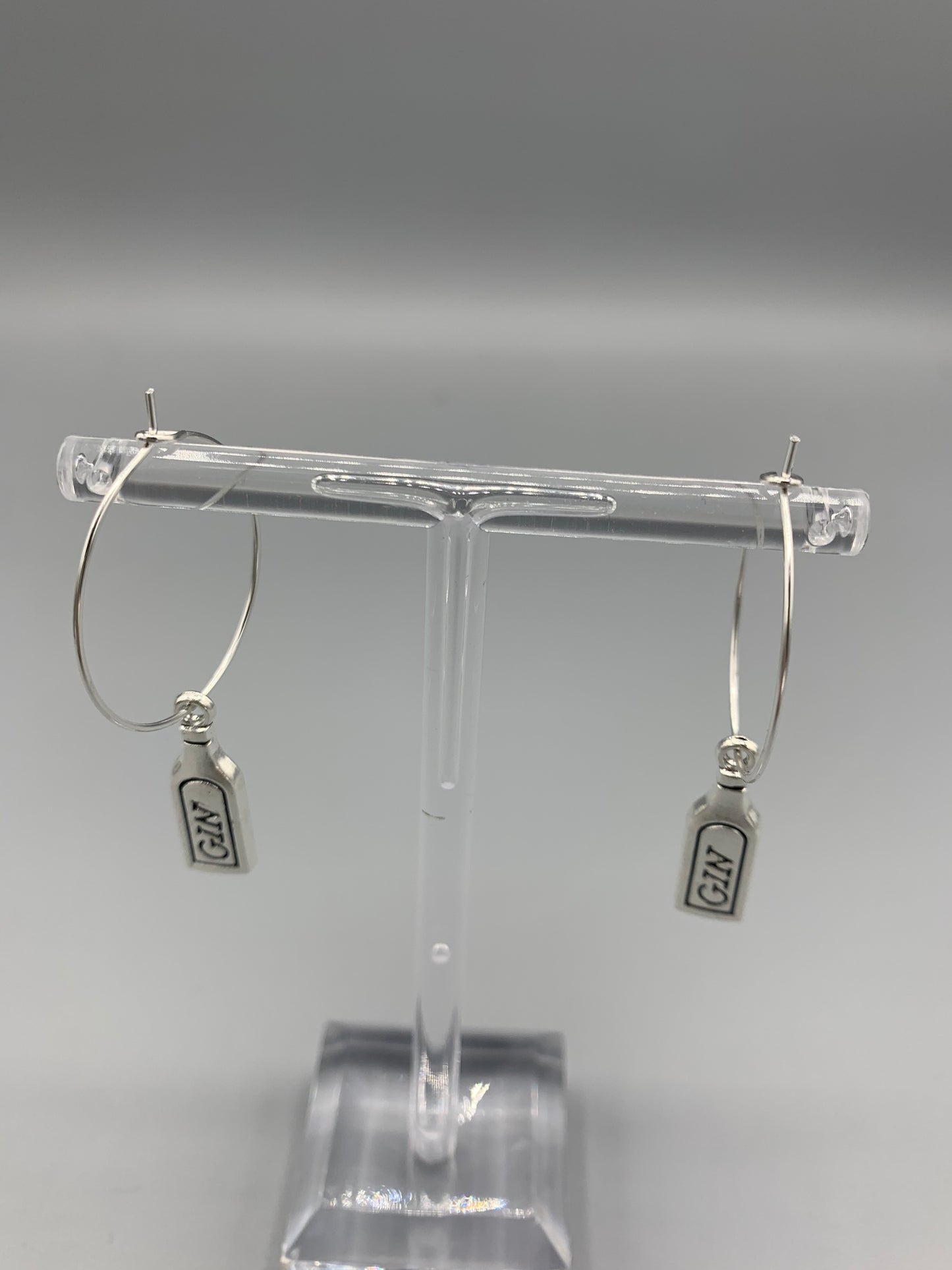 Gin bottle earrings. Alloy metal silver coloured gin bottle charm on silver plated hoops. metal earrings. fun earrings.