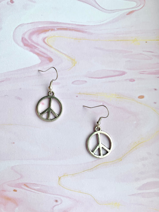 peace earrings. peace symbol silver coloured charm on silver plated hooks. dangle earrings. peace not war. statement earrings.