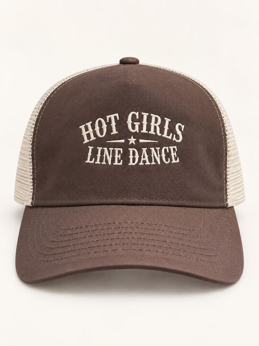 A brown and beige trucker hat with 'HOT GIRLS LINE DANCE' embroidered on the front, shown against a plain off-white background.
