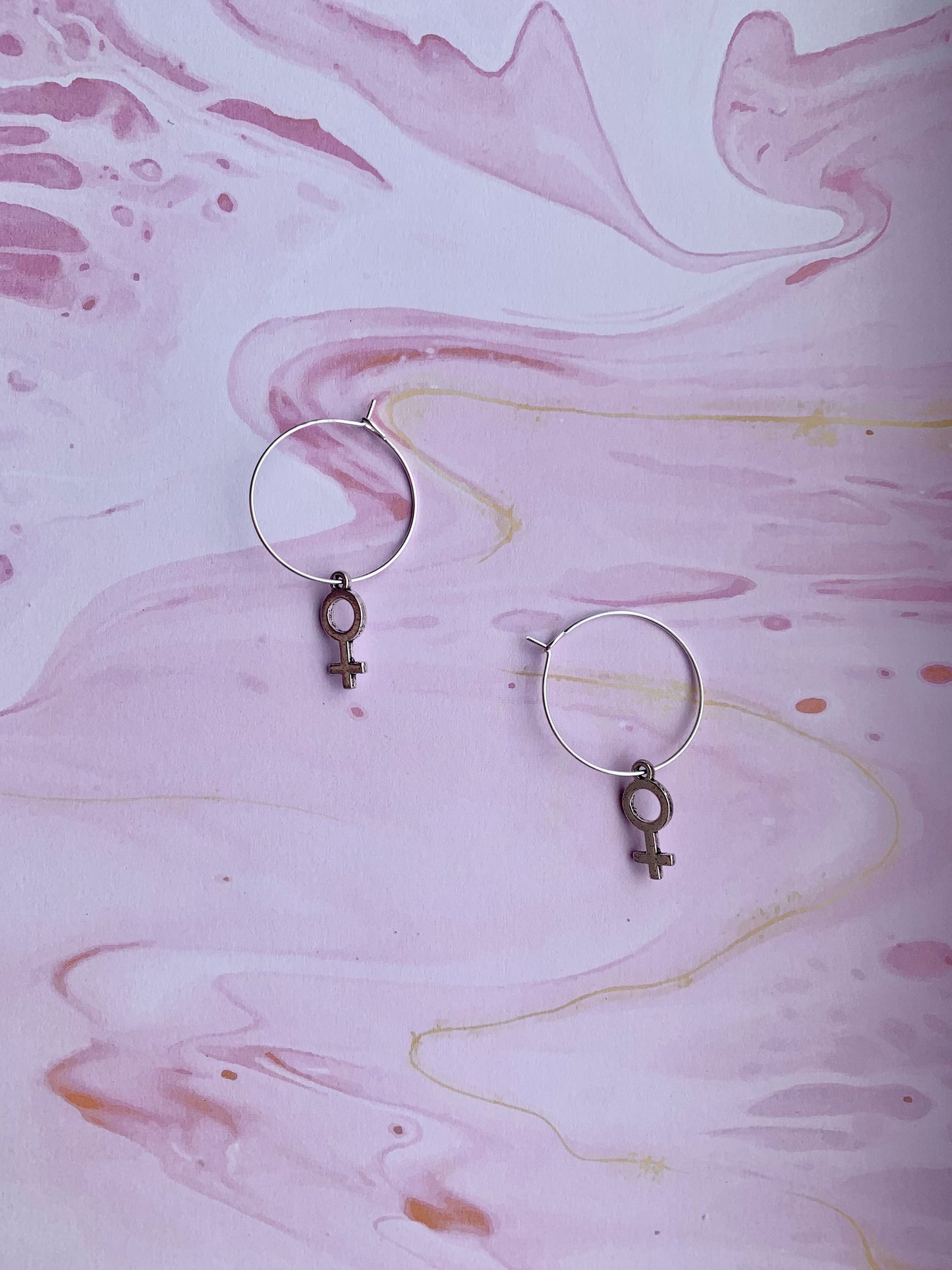 Silver coloured alloy female symbol charms on silver plated hoops. female earrings. feminist earrings. girl power. women power. earrings for women. earrings for girls. 