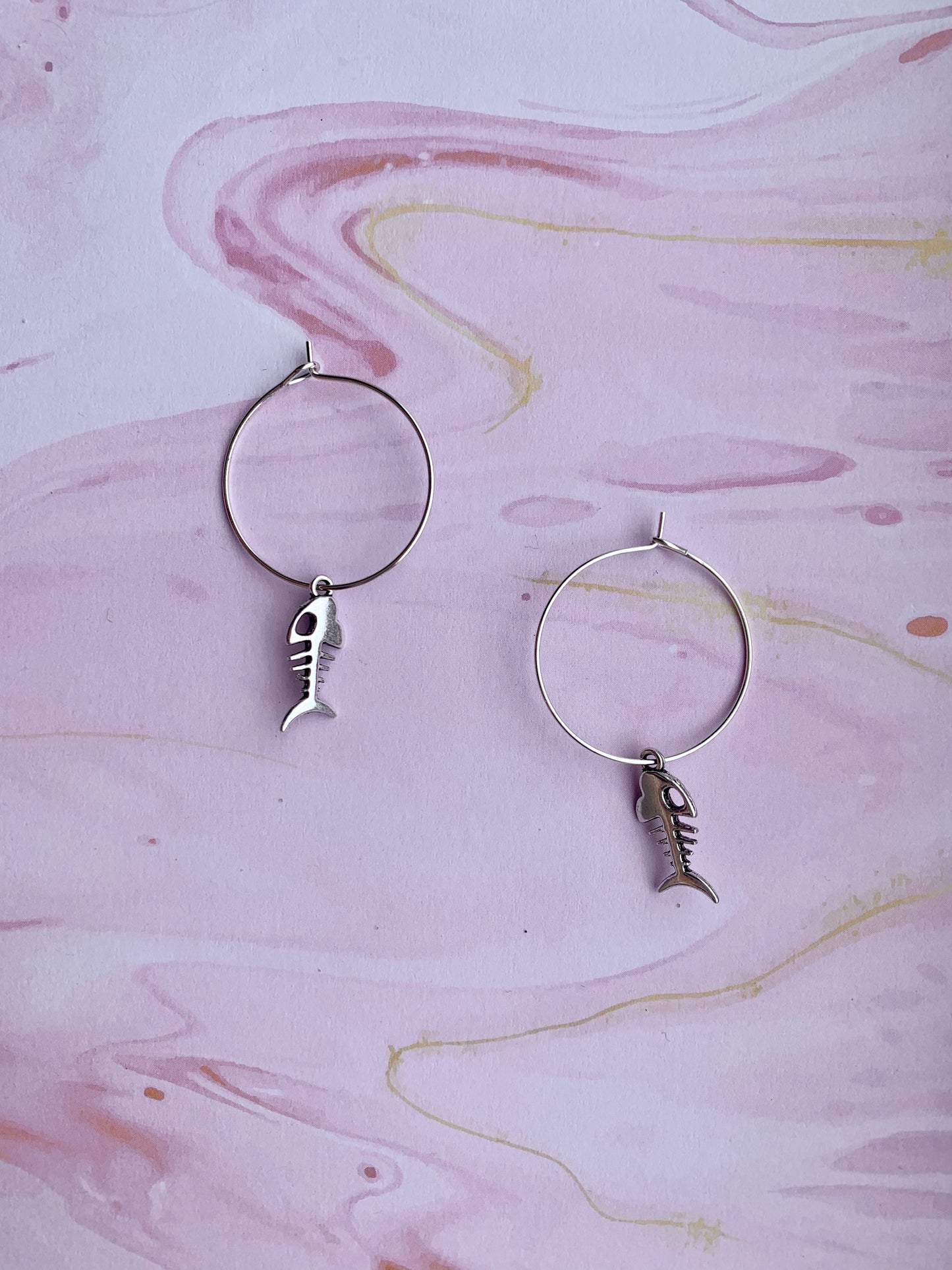 Alloy silver coloured fish skeleton charm on silver plated hoops. dangle earrings. goth earrings. bone earrings. hoop earrings. 