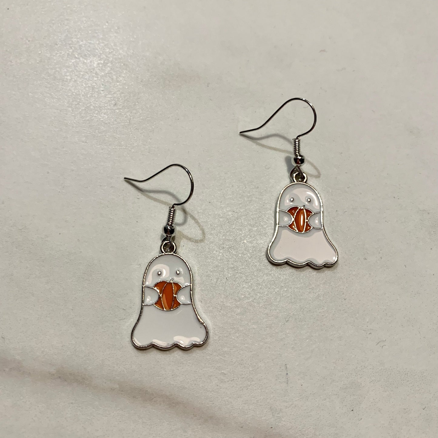 Earrings with  a white ghost holding an orange pumpkin  