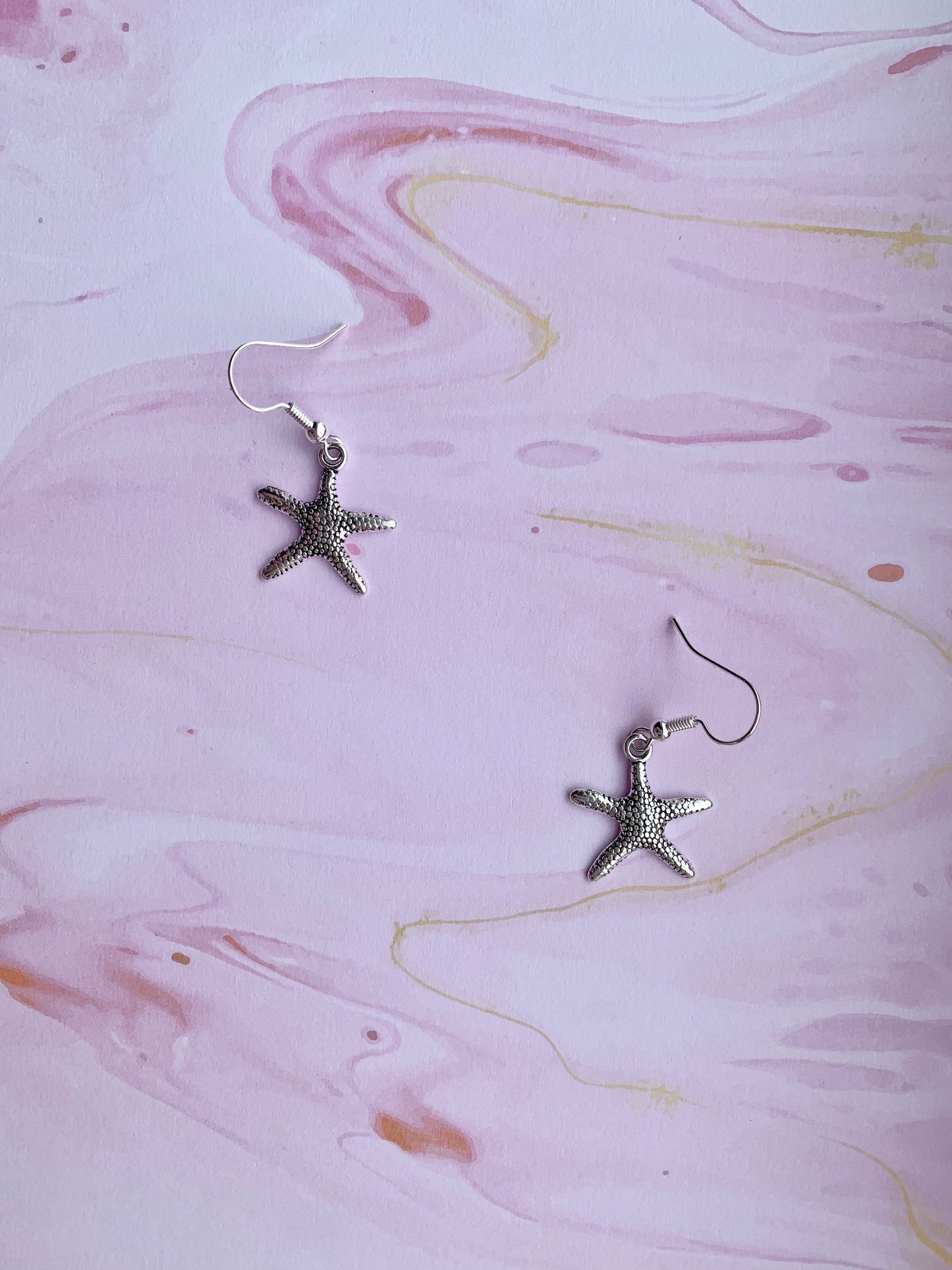 starfish earrings. mermaid earrings. alloy silver coloured charm on silver plated hooks. cute earrings. dangle earrings. holiday earrings.