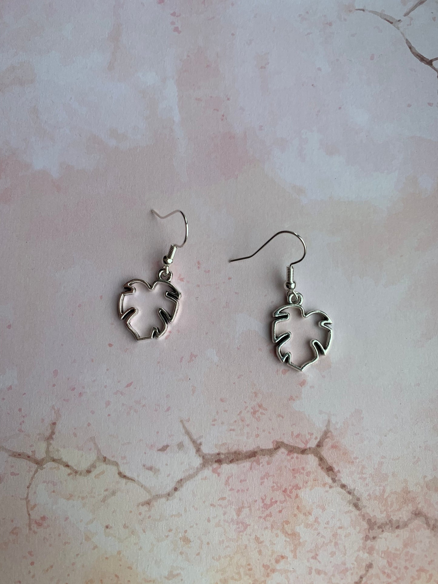 Tropical leaf outline in silver coloured alloy metal charm on silver plated hooks. Pretty earrings. Tropical earrings. Nature earrings. 